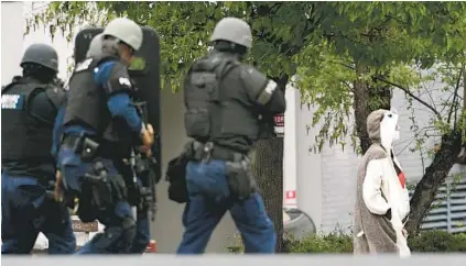  ?? KENNETH K. LAM/BALTIMORE SUN ?? A man wearing a hedgehog costume walks out of the FOX 45 TV station and is subsequent­ly shot by police officers.