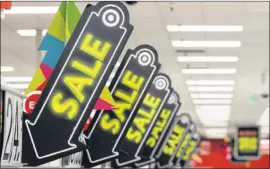  ?? JEFF CHIU / AP ?? Sale signs at a Target store entice Black Friday shoppers last month. Big retailers are engaging in a price war this holiday season, and shoppers can score some good deals if they know how to navigate them.