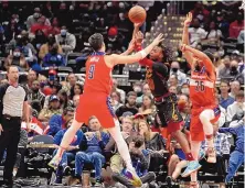  ?? LUIS M. ALVAREZ/ASSOCIATED PRESS ?? Cleveland’s Darius Garland (10) passes the ball while defended by Washington’s Deni Avdija (9) and Spencer Dinwiddie on Tuesday night.