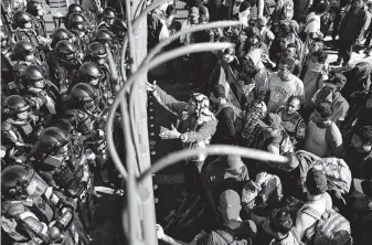  ?? Photos by Marco Ugarte / Associated Press ?? Migrants plead with Mexican national guardsmen Saturday at a border crossing in Tecun Uman, Guatemala. Many migrants leaving Central America say they fear for their lives back home.