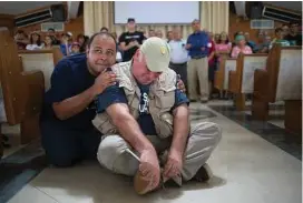  ??  ?? Pastor Eliomar Santana gives José Andrés a hug as they watch a video that members of the Jesucristo Monte Moria Pentecosta­l Church made to honor the chef ’s aid to the Hurricane-ravaged island, in Naguabo, Puerto Rico, on Oct. 19.
