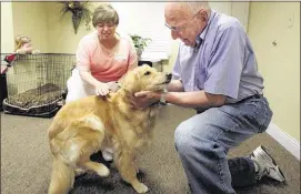  ?? StAn CArroll/the CommerCiAl APPeAl ?? sally, an 8-year-old Golden retriever, gets pampered by residents Catherine Feldman (left) and Jerry Klein at the Village at Germantown, a senior living facility.