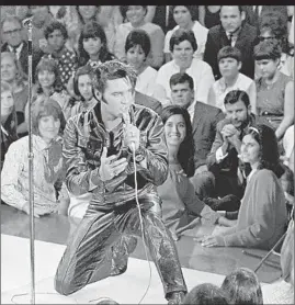  ??  ?? Above: Steve Binder and Elvis Presley talk during rehearsals for the 1968 TV special. Below: Presley performs an in-the-round jam session before a live studio audience.