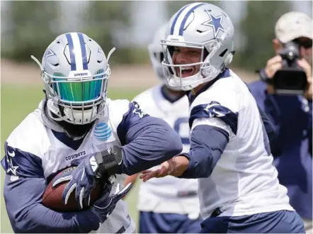  ?? (Photo by Tony Gutierrez, AP) ?? Dallas Cowboys running back Ezekiel Elliott, left, takes the handoff from former Mississipp­i State quarterbac­k Dak Prescott, during Tuesday's practice at the team facility.