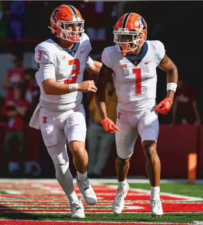  ?? GETTY IMAGES ?? Illinois wide receiver Isaiah Williams (right) celebrates with QB Tommy DeVito after their TD connection in the first quarter.