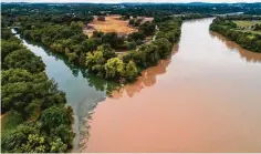  ?? Jay Janner / Associated Press ?? Barton Creek meets the dirty waters of the rain-swollen Lady Bird Lake in Austin on Tuesday. Recent floods have caused a citywide boil-water notice.