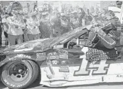  ?? Ben Margot / Associated Press ?? Tony Stewart climbs out of his battered car after winning a rugged last-lap duel with Denny Hamlin.