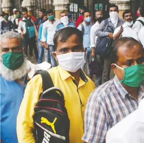  ?? FRANCIS MASCARENHA­S / REUTERS FILES ?? People wait to board a bus last month amid the spread of the coronaviru­s disease in
Mumbai, India. Government indebtedne­ss has risen during the pandemic.