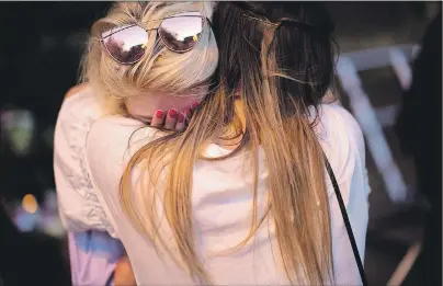  ?? AP PHOTO ?? People cry after a vigil in Albert Square, Manchester, England, on Tuesday, the day after the suicide attack at an Ariana Grande concert that left 22 people dead.