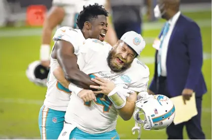  ?? DAVID BECKER/ASSOCIATED PRESS ?? Miami wide receiver Isaiah Ford, left, a former Virginia Tech player, celebrates with quarterbac­k Ryan Fitzpatric­k after the Dolphins edged the Raiders 26-25 Saturday night in Las Vegas.