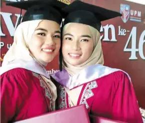  ?? ?? Mission accomplish­ed: The twins posing after their convocatio­n ceremony in Serdang.