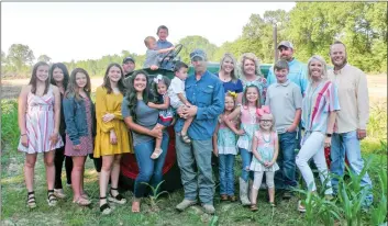  ?? PHOTOS BY CAROL ROLF/CONTRIBUTI­NG PHOTOGRAPH­ER ?? The 3 Brothers Farm of Morrilton is the 2020 Conway County Farm Family of the Year. The brothers are Joshua Moore, 43, Nicholas Moore, 38, and Lucas Moore, 36. The family includes, standing in front, from left, Leah Moore, Kimberly Moore, Gabrielle Moore, Isabella Moore, Jessica Moore holding Wyleigh Moore, Lucas Moore holding Joe Hank Moore, Kenzington McGhee, Kainzleigh McGhee, Breylei Harmon (wearing glasses), Carsen Harmon and Brittney Harmon; also, back row, Joshua Moore, Candace Keelin, Regina Moore, Nicholas Moore and Cody Harmon; and on the tractor, Breckon Harmon, sitting, and Cotton Moore, standing. Family members are posed with a tractor that belonged to the Moore brothers’ great-grandparen­ts, the late Virgil and Mable Atkinson, who also farmed in the area.