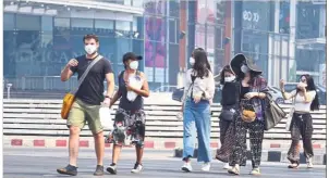  ?? — AP ?? Keeping safe: Tourists wearing masks in Chiang Mai as they make their way around the city.