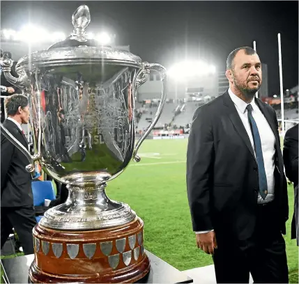  ?? PHOTO: PHOTOSPORT ?? This may be as close as Australian coach Michael Cheika gets to the Bledisloe Cup as he walks past the trophy on Saturday.