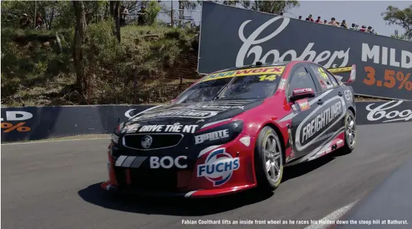  ??  ?? Fabian Coulthard lifts an inside front wheel as he races his Holden down the steep hill at Bathurst.