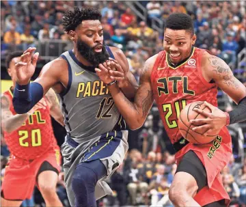  ?? / AP-R Brent Smith ?? Hawks guard Kent Bazemore moves toward the basket defended by Pacers guard Tyreke Evans during the first half of Saturday’s game in Indianapol­is.