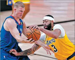  ?? MARK J. TERRILL/AP ?? Nuggets’ Mason Plumlee, left, and Lakers’ Anthony Davis compete for control Friday.