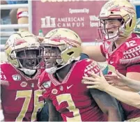  ?? STEVE CANNON/AP ?? Florida State’s Cam Akers, center, celebrates with teammates Alex Hornibrook, right, and Darius Washington Saturday in Tallahasse­e.