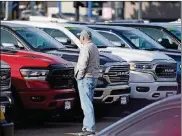  ?? AP PHOTO/DAVID ZALUBOWSKI ?? A prospectiv­e buyer surveys a long row of unsold 2020 pickup trucks at a Ram dealership on Dec. 27 in Littleton, Colo.