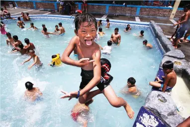  ?? (Jansen Romero) ?? SPLASH TIME – Children frolic in a public pool in Paco, Manila, on Wednesday. This month’s heat index could reach as high as 40 degrees.