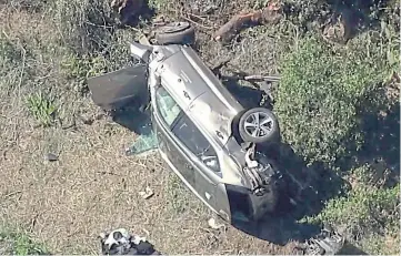  ??  ?? WRECKED: Woods’ car lies badly damaged by the roadside in Los Angeles.