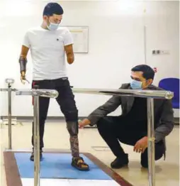  ??  ?? Hairuman testing a leg prothesis while Nasrul Anuar checks his progress. – ASYRAF RASID/THESUN