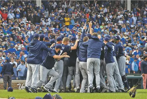  ??  ?? Brewers players celebrate Monday after defeating the Cubs 3-1 in a tiebreak game in Chicago. With the win, Milwaukee took the NL Central title.