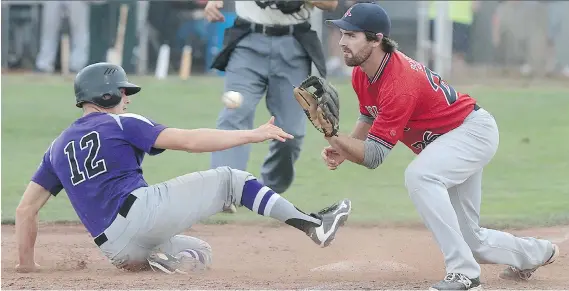 ?? DAN JANISSE ?? Tecumseh Thunder’s Jeff Watkin slides safely into third base in front of Milton’s Chris Pittaway during the Ontario senior eliminatio­n tournament on Friday at Lacasse Park.