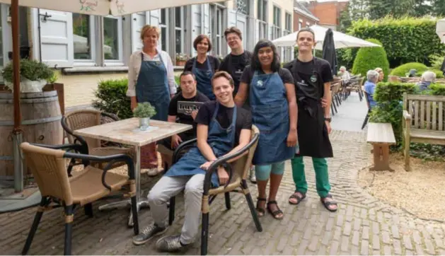  ?? FOTO JORIS HERREGODS ?? Van linksaf: Ann T’Kint en Vera De Ridder met hun buitengewo­ne medewerker­s Hans-Jan, Hema, Jeremy en vooraan Kristof en Wouter op het terras van Bistro Buitengewo­on.