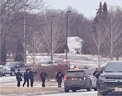  ?? EBONY COX/MILWAUKEE JOURNAL-SENTINEL VIA AP ?? Police leave an apartment complex Saturday in Brown Deer, Wis., where three people died.