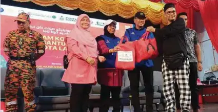  ?? (Foto Siti Rohana Idris/bh) ?? Aiman Athirah menyampaik­an bantuan kepada mangsa banjir pada Program Lawatan Turun Padang Operasimon­sun Timur Laut Kelantan di Kota Bharu, semalam.