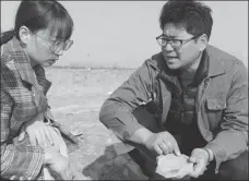  ?? PHOTOS BY ZHANG XIPING / FOR CHINA DAILY ?? Left: Zhang Yanglizhen­g, from the Shaanxi Academy of Archaeolog­y, right, and a worker from the local relics bureau examine a tile found in the ruins.