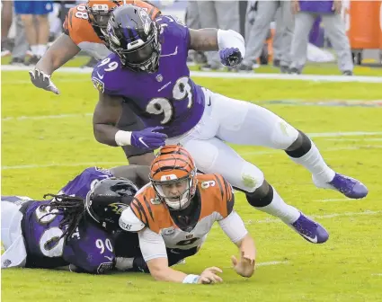  ?? KARL MERTON FERRON/BALTIMORE SUN ?? Ravens outside linebacker­s Pernell McPhee (90) and Matthew Judon (99) hit Bengals quarterbac­k Joe Burrow after a pass Sunday.