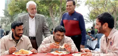  ?? Photos by Juidin Bernarrd ?? Naseem Durrani (standing left) with labourers during a Valentine’s Day surprise lunch organised by a senior citizen group in Dubai on Tuesday. More than 250 workers were invited to the party. —