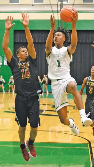  ?? STAFF PHOTO BY ROBIN RUDD ?? East Hamilton’s Andrew Williams (1) goes to the basket past Tyner’s Solomon Bridgeman on Friday night. The host Hurricanes won 62-49 at East Hamilton.