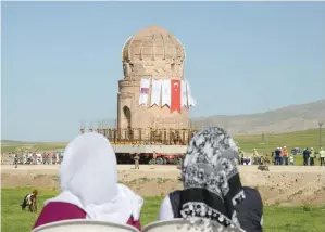  ?? — AFP ?? Local people watch the tomb of Zeynel Bey as it is carried on a rolling structure on Friday at Hasankeyf in Batman, southeaste­rn Turkey, as it is moved to stave off the risk of flooding from a dam project.