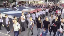  ?? ?? Schoolchil­dren carrying a giant portrait of Atatürk during a parade in Lefkoşa
