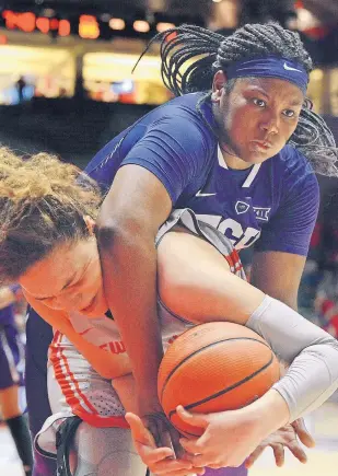  ?? JIM THOMPSON/JOURNAL ?? TCU’s Amy Okonkwo, rear, goes over the back of New Mexico’s Jaisa Nunn, who makes a rebound in their game in the Pit on Thursday night.