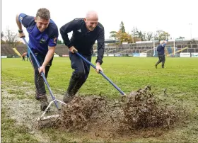  ?? ?? Enniskille­n Gaels members Rory Rafferty and Dermot Love try to clear water of the Brewster Park pitch on Sunday.