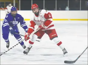  ?? Erik Trautmann / Hearst Connecticu­t Media ?? Greenwich’s Matt Davey makes an assist despite pressure from Darien’s Sean Bradley during the Winter Classic Saturday.