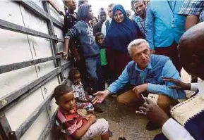  ?? AFP PIC ?? UN High Commission­er for Refugees Filippo Grandi (second from right) visiting a refugee camp for Libyans on Monday.