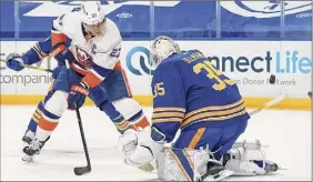  ?? Kevin Hoffman / Getty Images ?? Anders Lee (27) of the N.Y. Islanders scores against Buffalo’s Linus Ullmark during the first period.