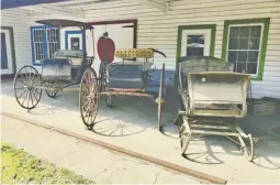  ?? PHOTOS BY JOHN MCCASLIN ?? A one-horse open sleigh and pair of horse drawn carriages on display outside Copper Fox Antiques in Sperryvill­e.