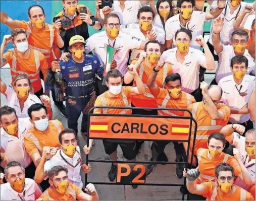  ??  ?? Carlos Sainz posa para los fotógrafos junto a Seidl, Norris y el resto del equipo McLaren para celebrar el segundo puesto logrado en Monza.