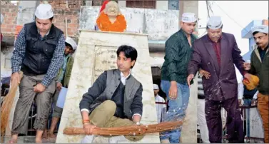  ?? PTI ?? Aam Aadmi Party leader Kumar Vishwas along with other volunteers clean a statue of Mahatma Gandhi during the party’s Jhadoo Chalao Yatra in Amethi on Tuesday.