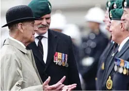  ??  ?? Last hurrah: Philip meets Marines at yesterday’s parade. Right: Tipping his bowler, he reveals his hearing aids