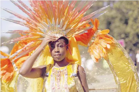  ?? — AFP ?? A girl in costume poses for a photograph on the first day of the Notting Hill Carnival in west London on Sunday.