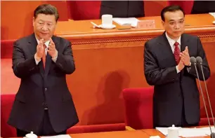  ?? AFP ?? Xi Jinping and Premier Li Keqiang applaud during a ceremony to commemorat­e the 90th anniversar­y of the founding of the People’s Liberation Army, in Beijing on Tuesday. —