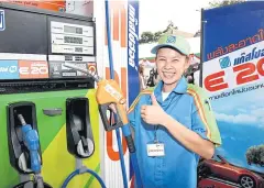  ?? PONGTHAI WATTANAVAN­ITVUT ?? A petrol station worker promotes Gasohol E-20 which is to become the primary gasoline for the country in early March.