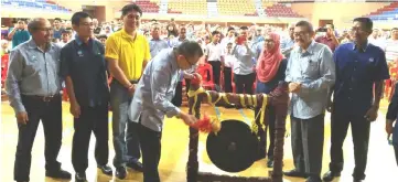  ??  ?? Ahmad Lai strikes the gong to officially launch the Miri Fishermen Associatio­n (PNK) annual general meeting at Miri Indoor Stadium witnessed by Cr Jamali (second right) and others